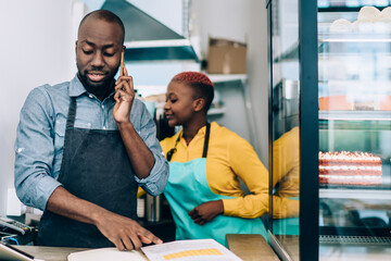 Fototapeta premium Ethnic man and woman working in cafe