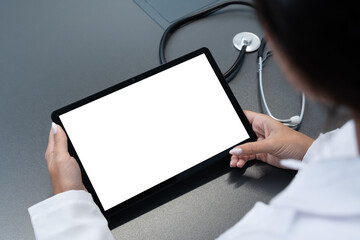Doctor looking at blank mockup tablet computer with white screen for copy space. Background for...