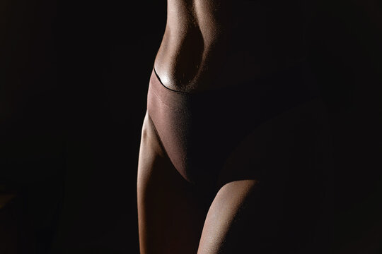 Cropped image of female body, muscular belly, leg. Model standing in underwear. Studio background. Concept of natural beauty, body and skin care, health, sport