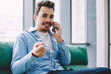Successful freelancer calling on smartphone at workplace