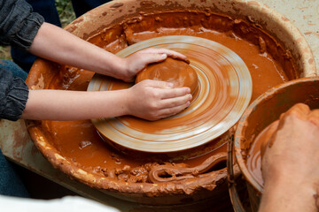 Pottery training. Rotating a clay pot on a machine. Hands knead clay. Making a clay pot.