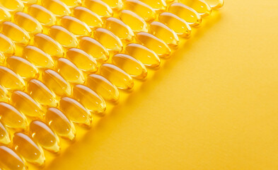 Dietary supplement in the form of vitamin capsules on yellow background. Banner for production of...