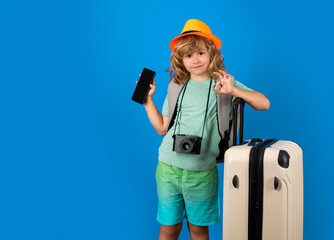 Child tourist with travel bag travelling. Kid with suitcase on studio isolated background.