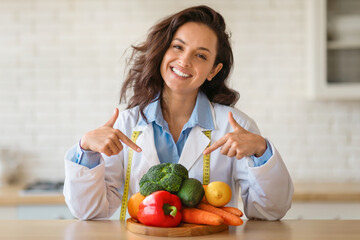 Happy dietitian pointing at fresh produce with tape measure