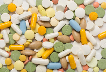 Different medical pills and capsules as background, top view