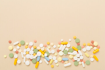 Different medical pills and capsules on color background, top view