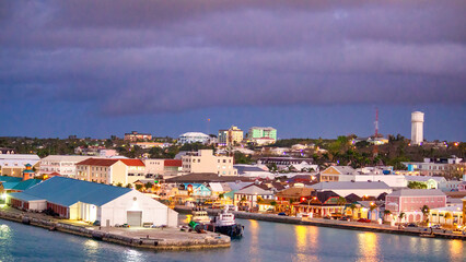 Fototapeta na wymiar Nassau, Bahamas - February 20, 2012: Colorful city buildings along the coastline at night
