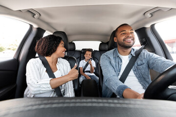 Happy black family enjoying car ride together - obrazy, fototapety, plakaty
