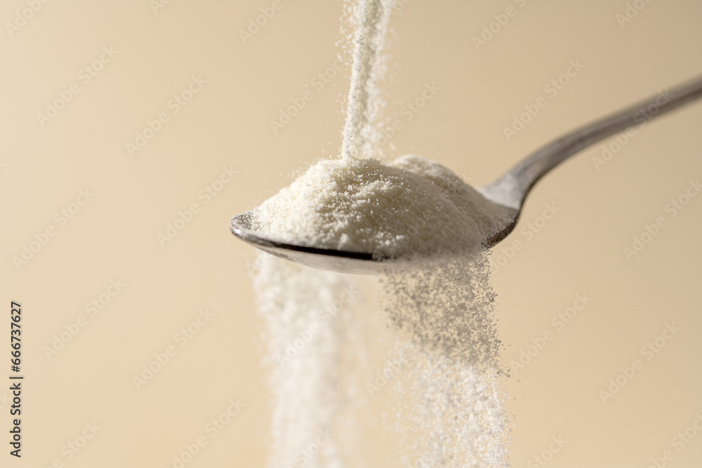 Wall mural collagen protein powder pouring in a spoon. food beauty and health supplement