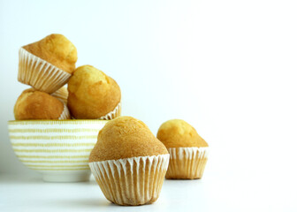 Close up. baked muffin on white background and porcelain bowl.