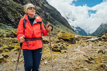 Papier Peint photo autocollant Makalu Portrait of Woman in sunglasses with backpack and trekking poles dressed red softshell jacket hiking on Makalu Barun National Park trek in Nepal. Mountain hiking, traveling and active people concept