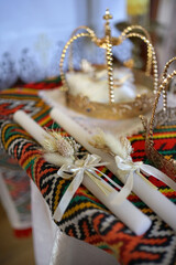 Church crowns and candles in the church on the throne. Church wedding items.