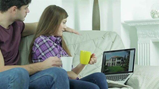 Girlfriend shows her boyfriend design a new building on the laptop