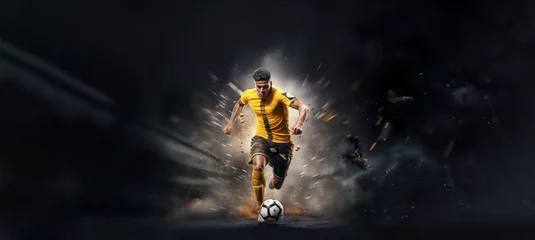 Fotobehang football or soccer player running fast and kicking a ball while training at dramatic stadium shot, dynamic active pose of skill development success in sports championship wide banner © sizsus