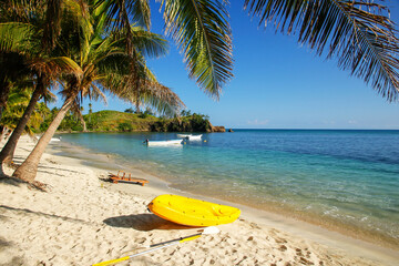 Sea kayak on the beach near palm trees