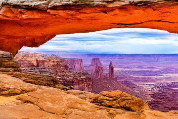 Mesa Arch with an incoming storm,.view to canyon and washerwoman Arch,Island in the Sky District.Canyonlands National Park, Utah, USA