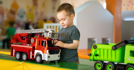 Cute toddler boy playing with cars in children's playroom. Active lifestyle, childhood. Selective...