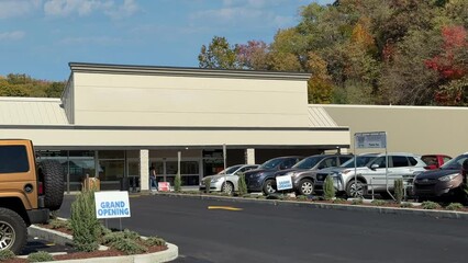 A daytime exterior DX establishing shot of an unbranded, generic American grocery store. Blank marquee for customization.	