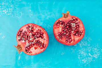 Trendy scene with fresh pomegranate in water. Minimal nature background concept. Creative healthy...
