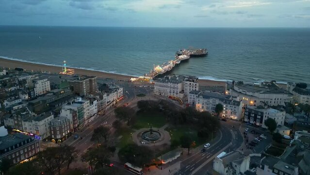 Aerial drone shot heading towards the lit up pier Brighton Pier
