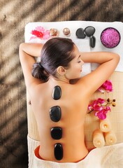 Obraz na płótnie Canvas Spa therapy with hot stones on young woman