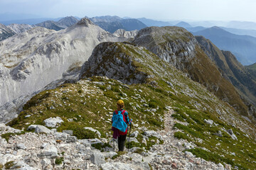 Fototapeta na wymiar Adult Woman Hiker Hike Between Krn and Batognica Mountain on a very scenic Alpine trail in Julian Alps - Slovenia