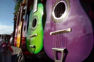 Colorful guitars on display in an outdoor marketplace showcasing vibrant designs