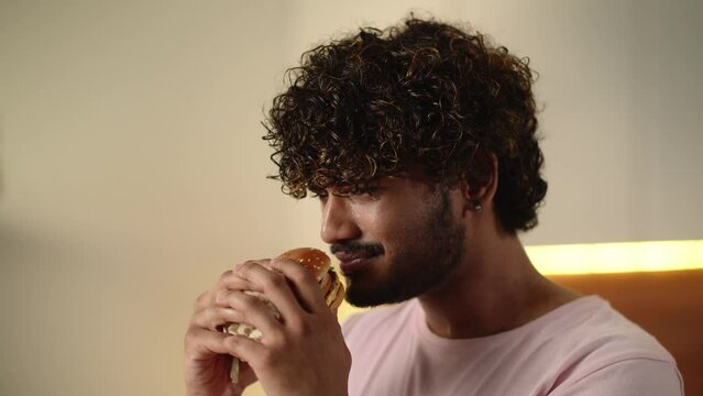Concept of unhealthy nutrition. Man feeling unpleasant smell his burger. Funny guy dont like eating spoiled hamburger. Student hates low quality cheeseburger. Terrible stink sandwich