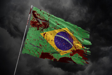 Brazil torn flag on dark sky background with blood stains.
