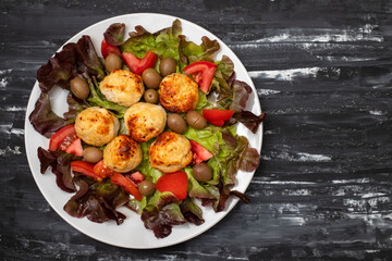 Chicken meatballs on lettuce with tomato and olives