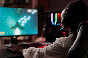 Naklejka premium Frustrated gamer losing online multiplayer spaceship arcade racing videogame, being defeated by more powerful opponents. African american woman unable to keep up with more skillful players