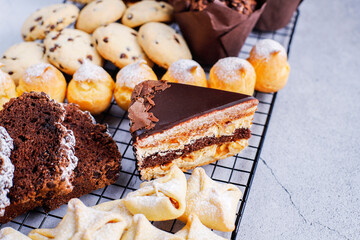 Table with various cookies, pound cake, cake slices, muffins and sweets.