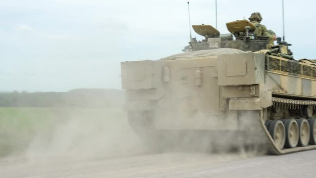 British army Warrior FV510 IFV moving along a dusty dirt track at speed