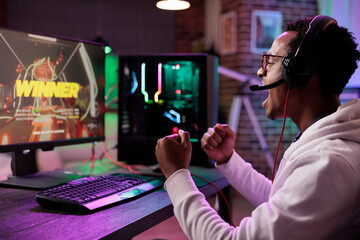 African american gamer cheerful about winning online multiplayer competition against other players....