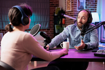 Show host interviewing guest during live stream, talking about fashion and style trends. Man...