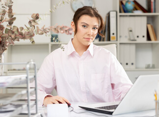 Office worker woman is working at a computer in the office