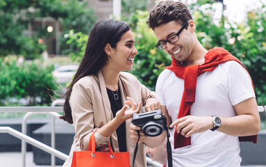 Happy enamored couple using camera on city street