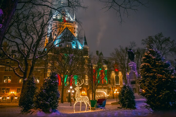 Obraz premium Place d'Armes and historic Fairmont Le Chateau Frontenac hotel during winter holidays, with Christmas decorations including reindeer and sleigh, old Quebec City, Canada. Photo taken in December 2022.