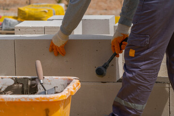 The bricklayer is working. Building a wall of aerated concrete.