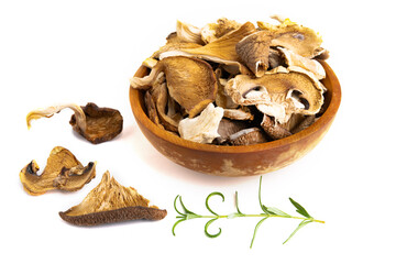 Assorted edible dried mushrooms in a wooden bowl isolated on a white background.
