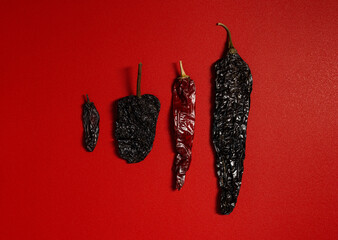 Dried Chilis Red background, chile guajillo Pasilla mexican spice variety size flat lay