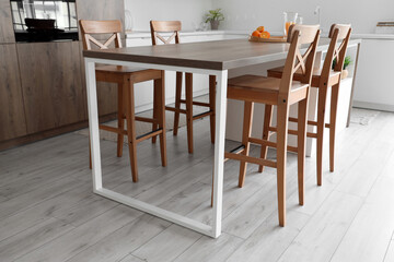 Wooden table and chairs in interior of light kitchen