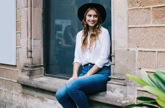 Young woman sitting outside of old building