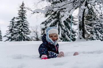 Fototapeta na wymiar Little girl playing in a deep snow