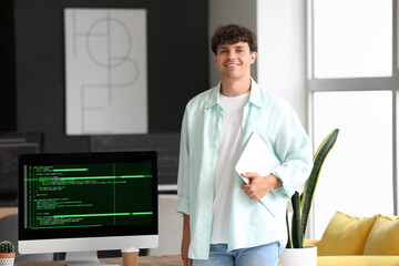 Male programmer with laptop working in office