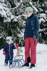 Little girl playing with mother on deep snow