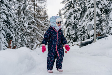 Little girl playing in a deep snow