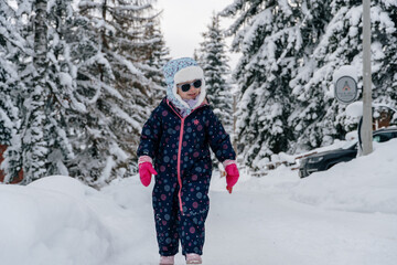 Little girl playing in a deep snow