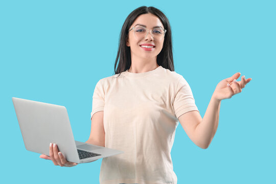Female programmer with laptop on blue background