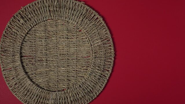 Placing a Mexican plate with dried chili peppers on a round woven tablecloth